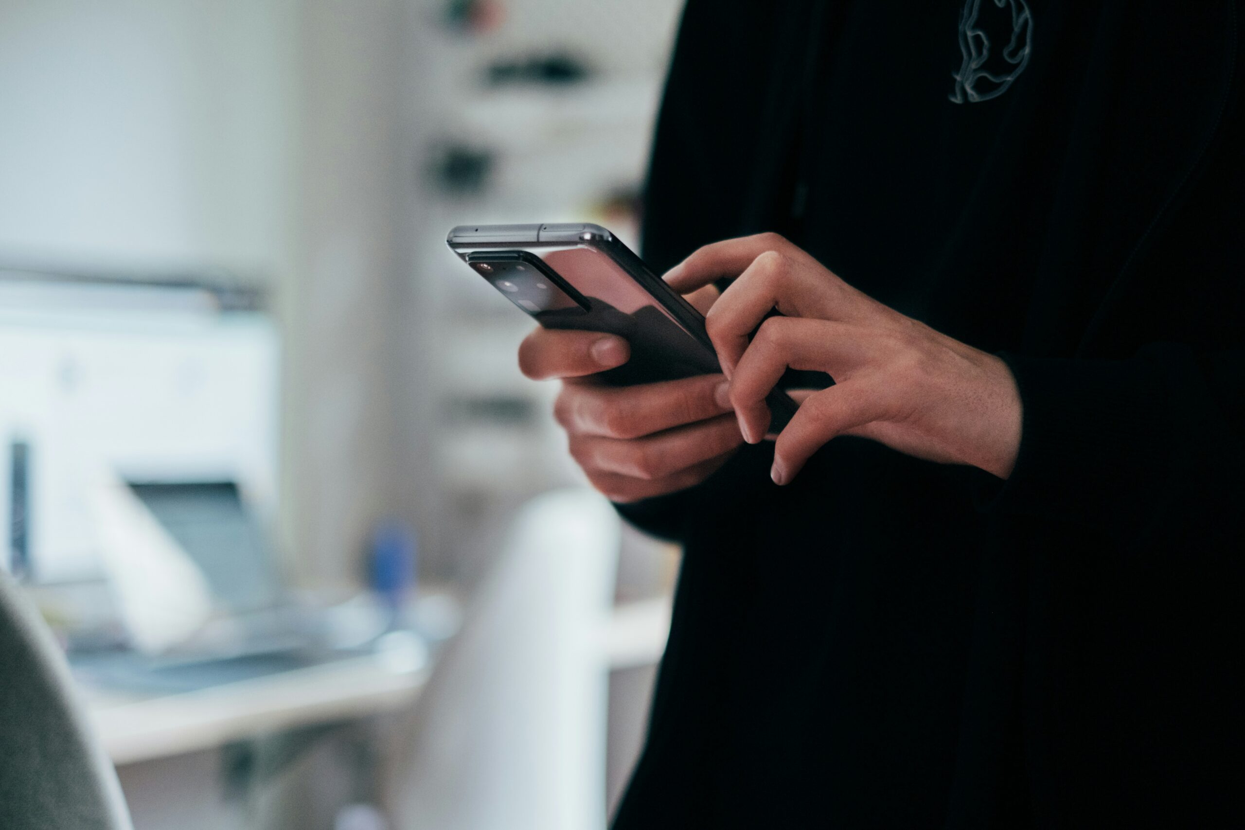 Prompt engineering: profesional escribiendo un prompt en su celular en la oficina