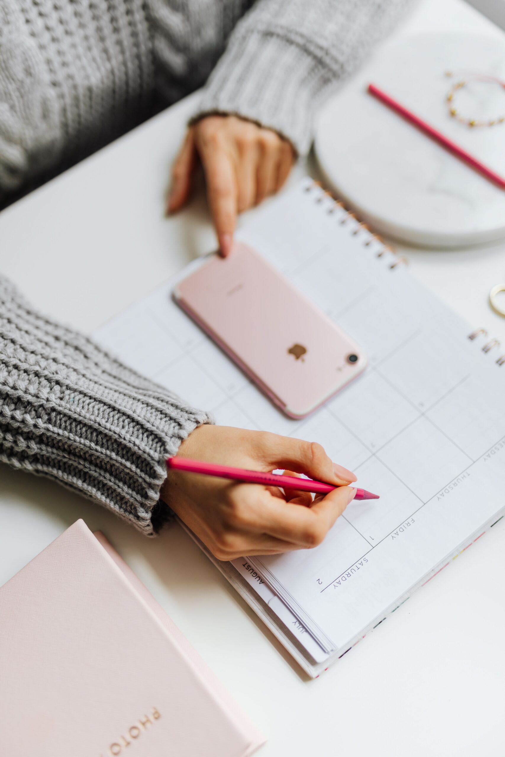 Persona haciendo gestión estratégica de la agenda con calendario y celular
