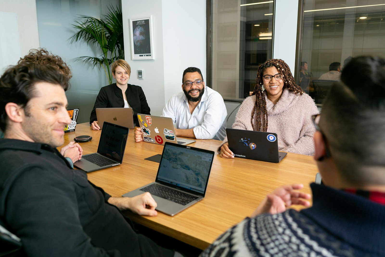 Equipo escuchando a un líder con liderazgo humilde en una reunión de trabajo