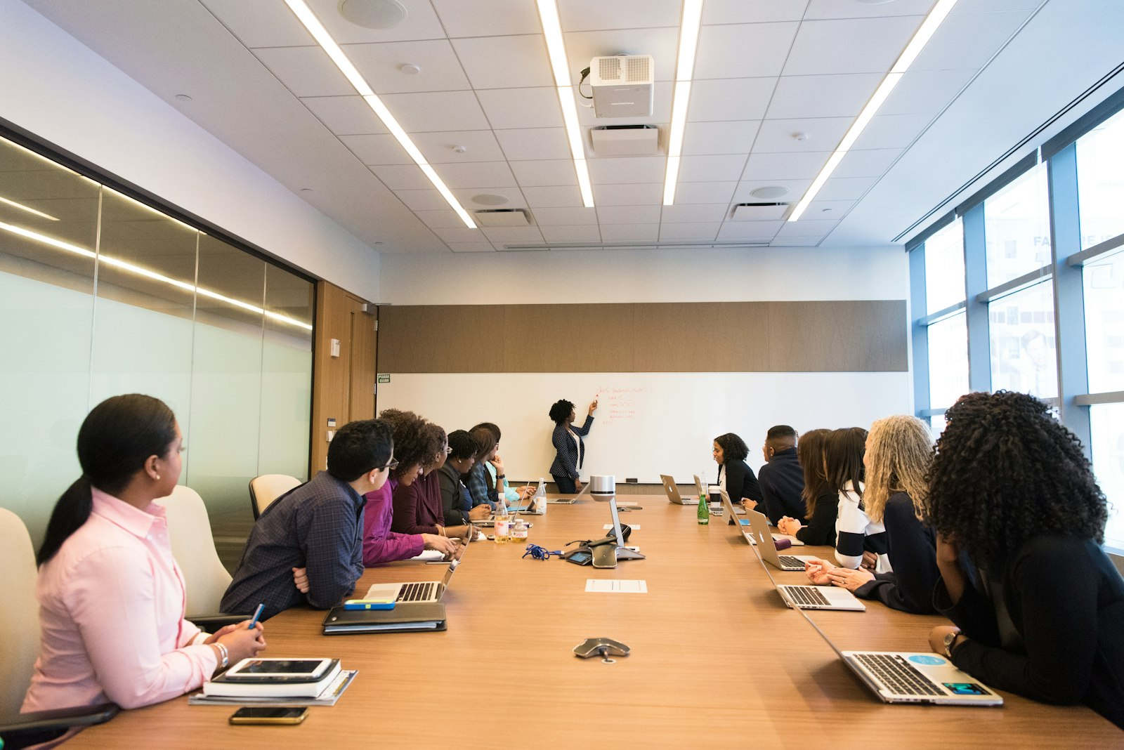 Líder conduciendo una reunión de equipo frente a una pizarra, imagen sobre capacitación para nuevos líderes