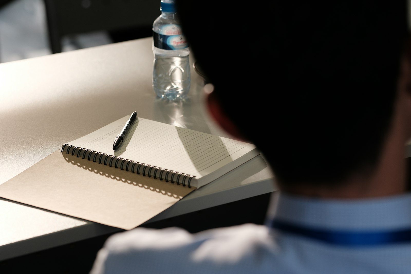 Cuaderno y birome sobre un escritorio durante una capacitación, ejemplo de la curva del olvido en capacitación